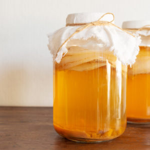 jar of fermenting organic kombucha on table